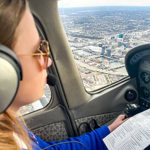 Girl flying in airplane above Grand Rapids